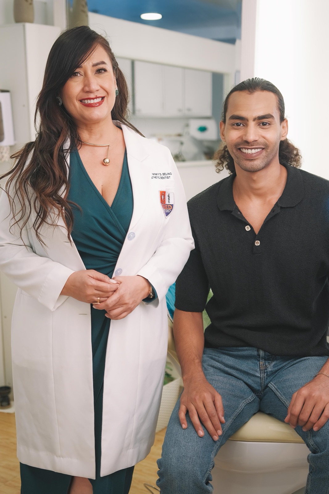 Dr Twinky standing beside a seated patient reviewing a smile makeover plan