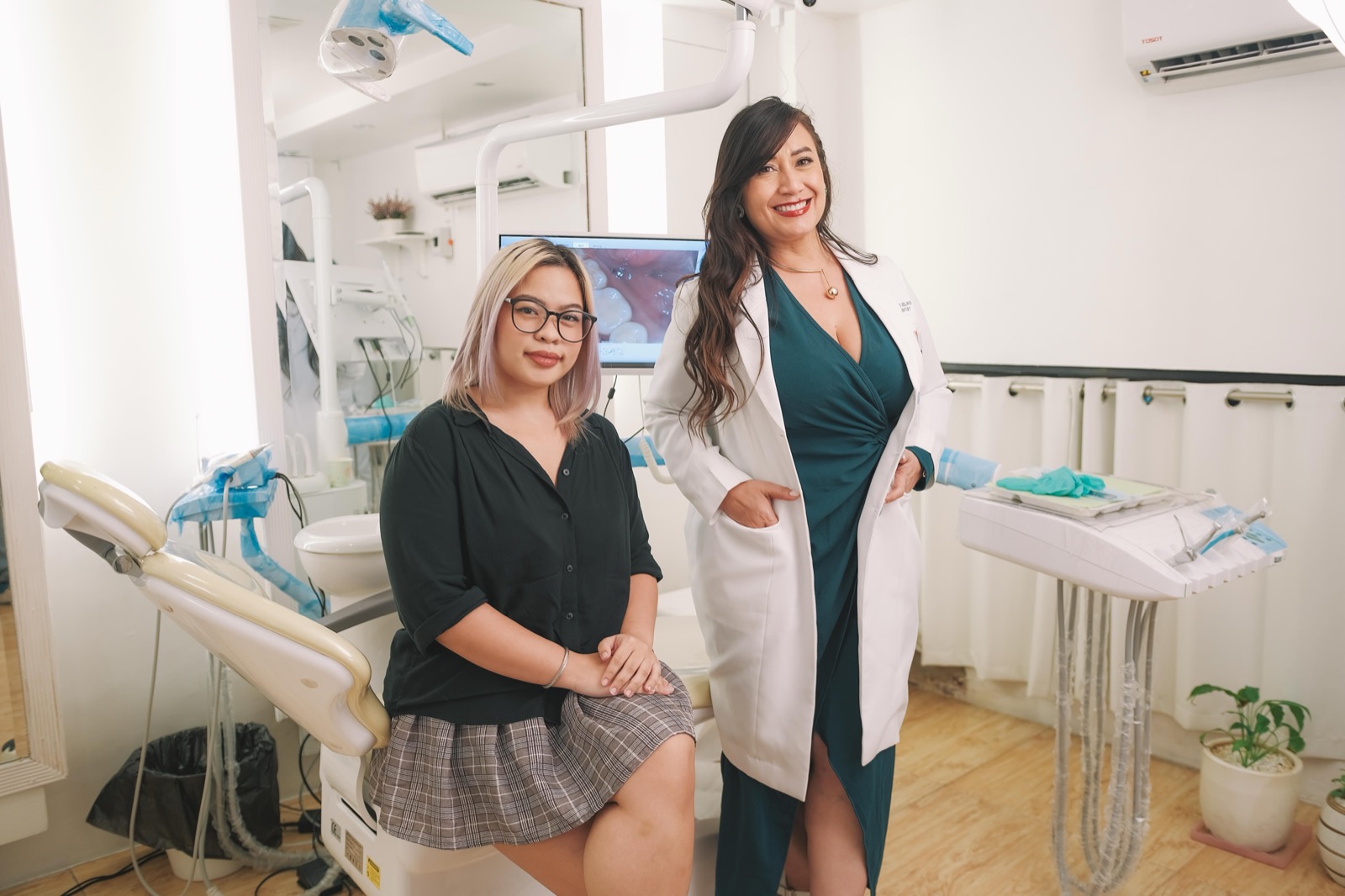 Dr Twinky posing with a clear-aligner patient in the treatment room